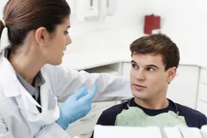 Zahnärztin im Beratungsgespräch mit einem Patienten